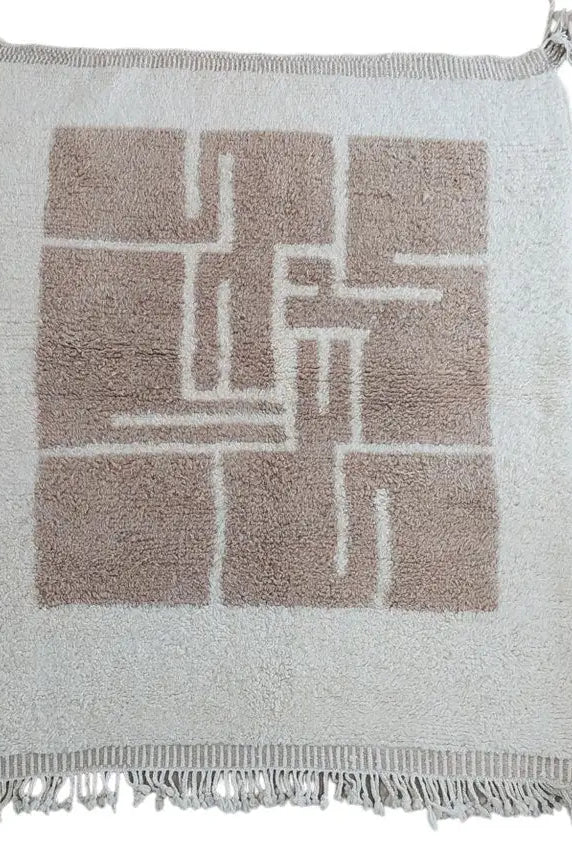 Moroccan rug with geometric pattern and fringe on a white background