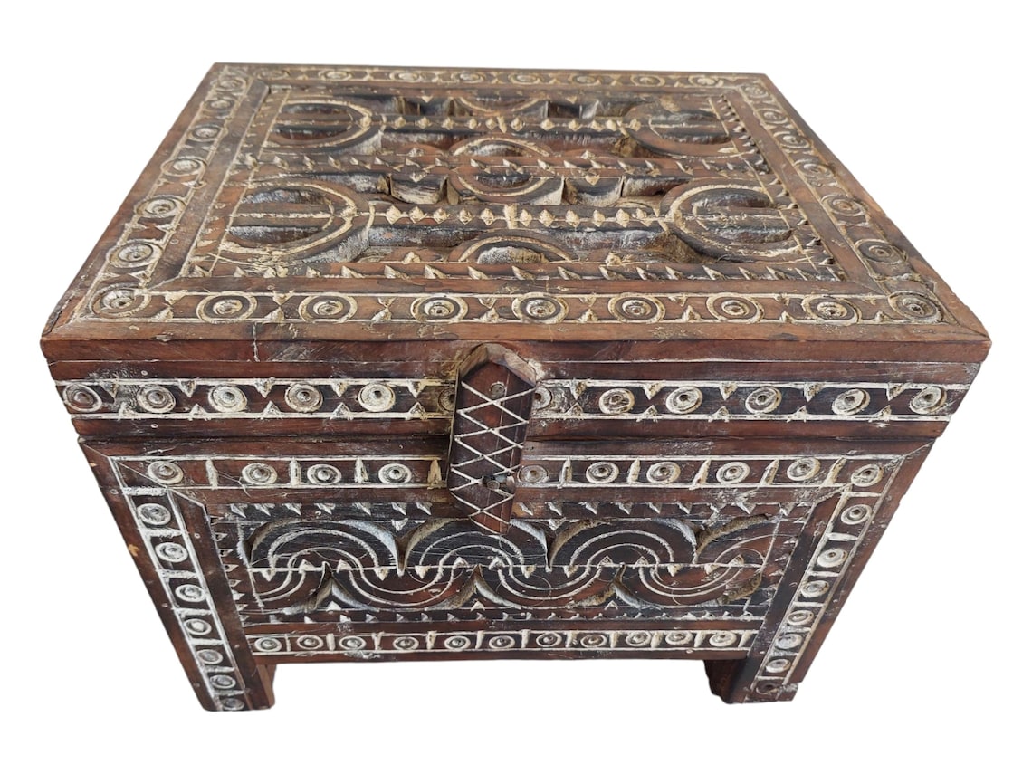 Decorative wooden box with intricate carvings on a white background