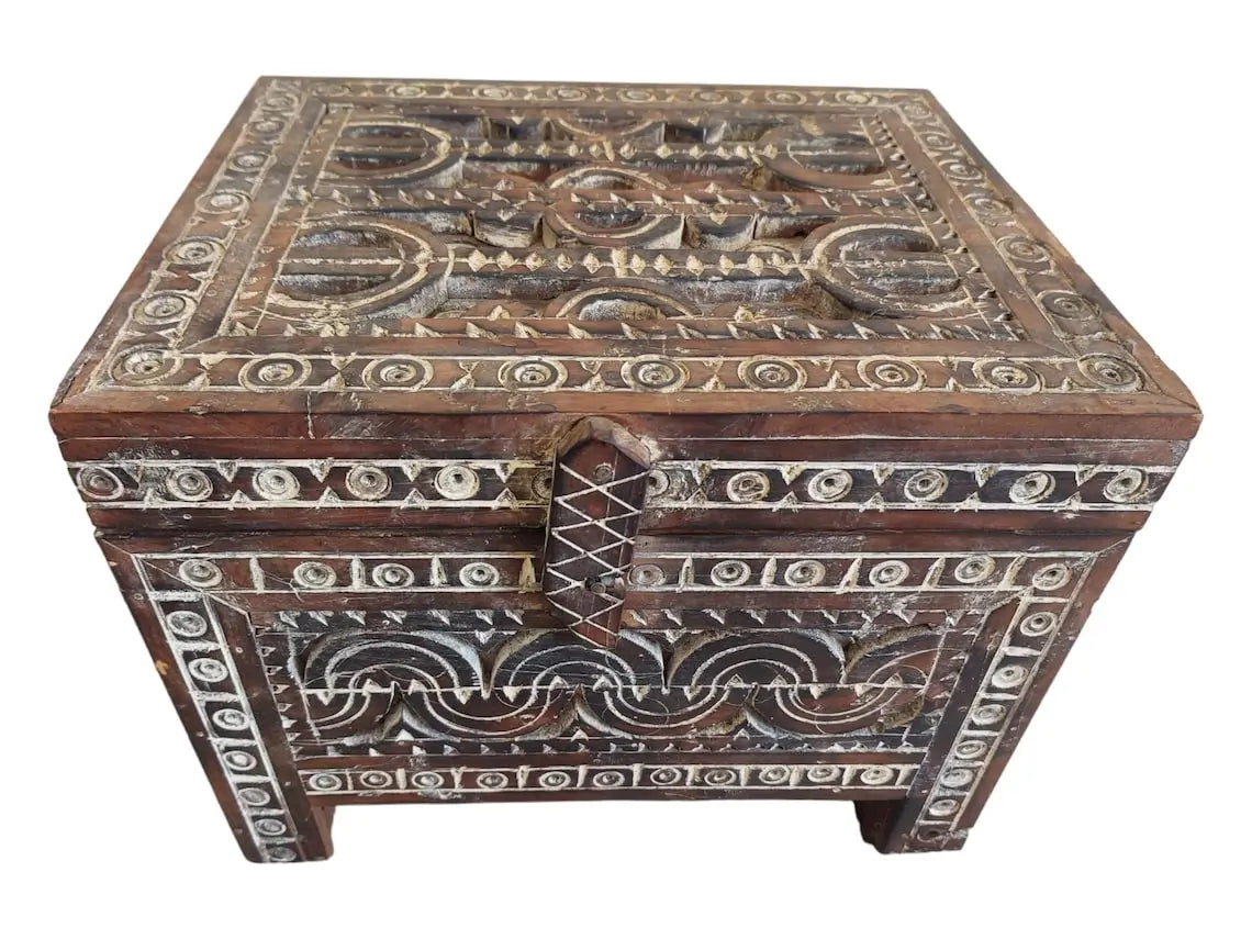 Decorative wooden box with intricate carvings on a white background