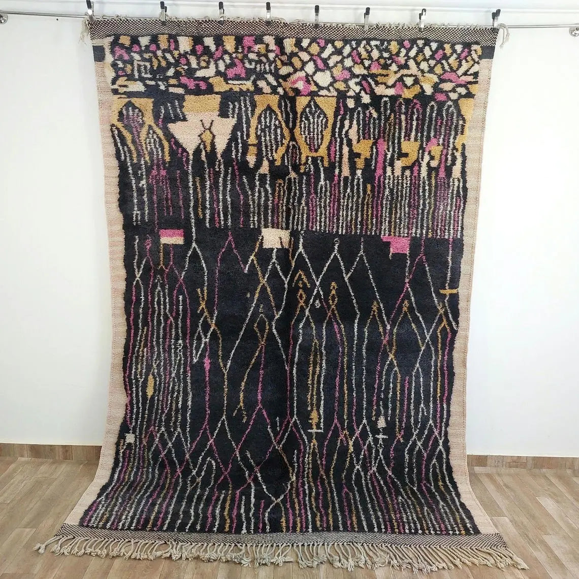 Moroccan rug , beni mrirt style with geometric pattern on a wooden floor