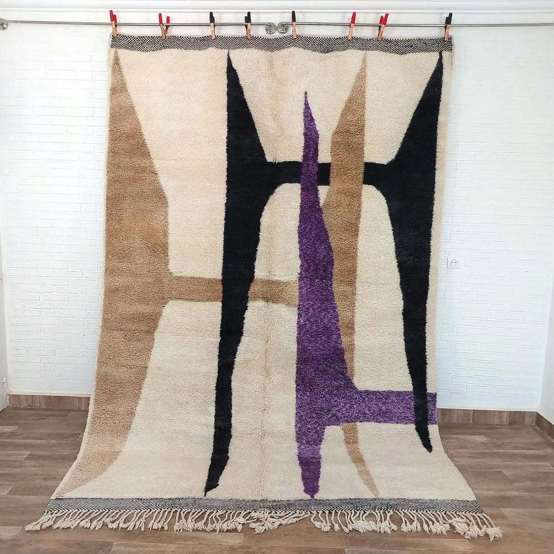 Moroccan beni mrirt rug art piece with geometric design on a wooden floor.