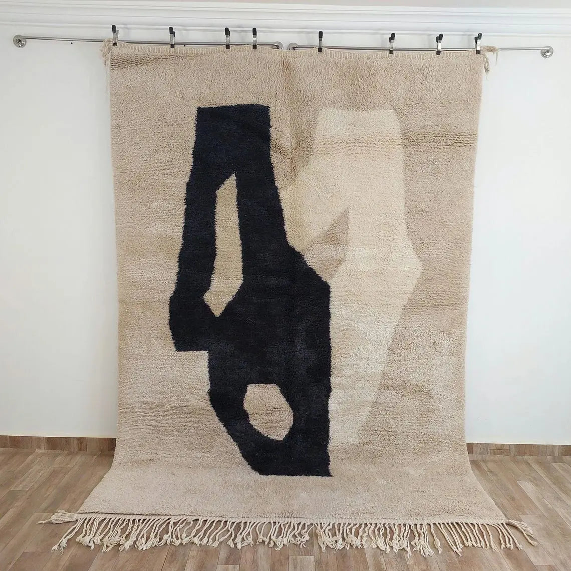 Beni mrirt rug on a beige background, hanging against a white wall.