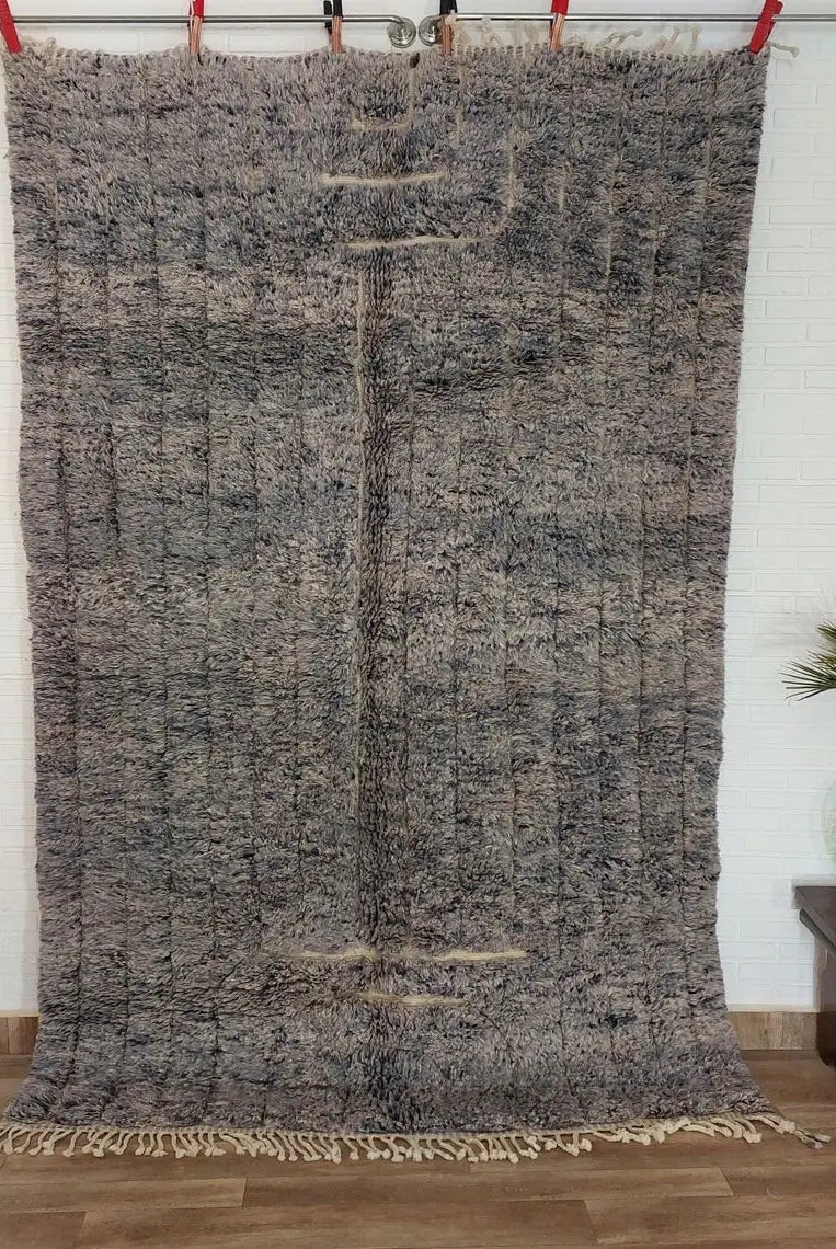 Textured area rug on a wooden floor with a white wall background