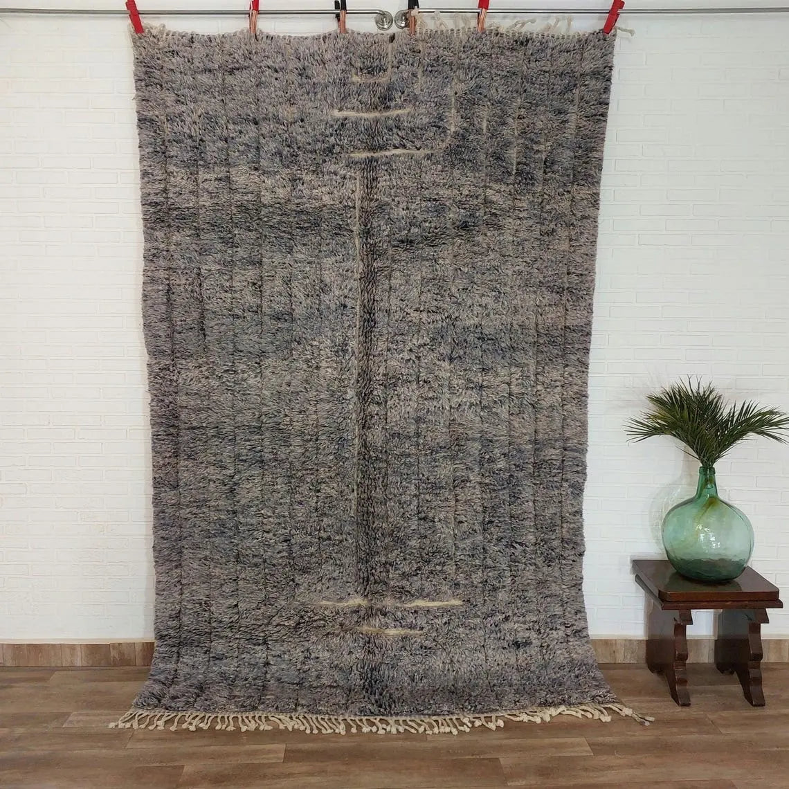 Textured area rug on a wooden floor with a white wall background