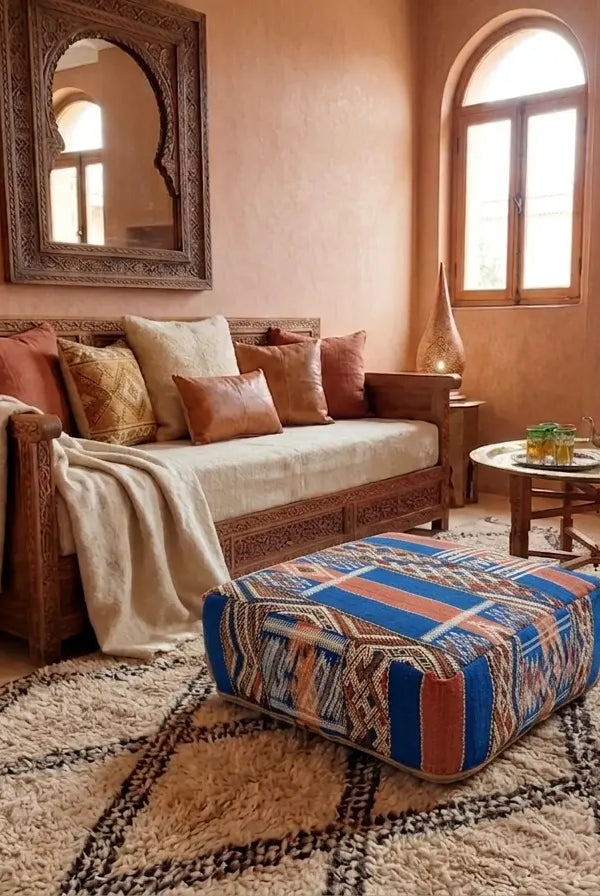 Living room with a wooden sofa, colorful ottoman, and decorative items.