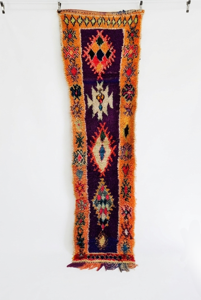 Colorful patterned rug hanging on a white wall