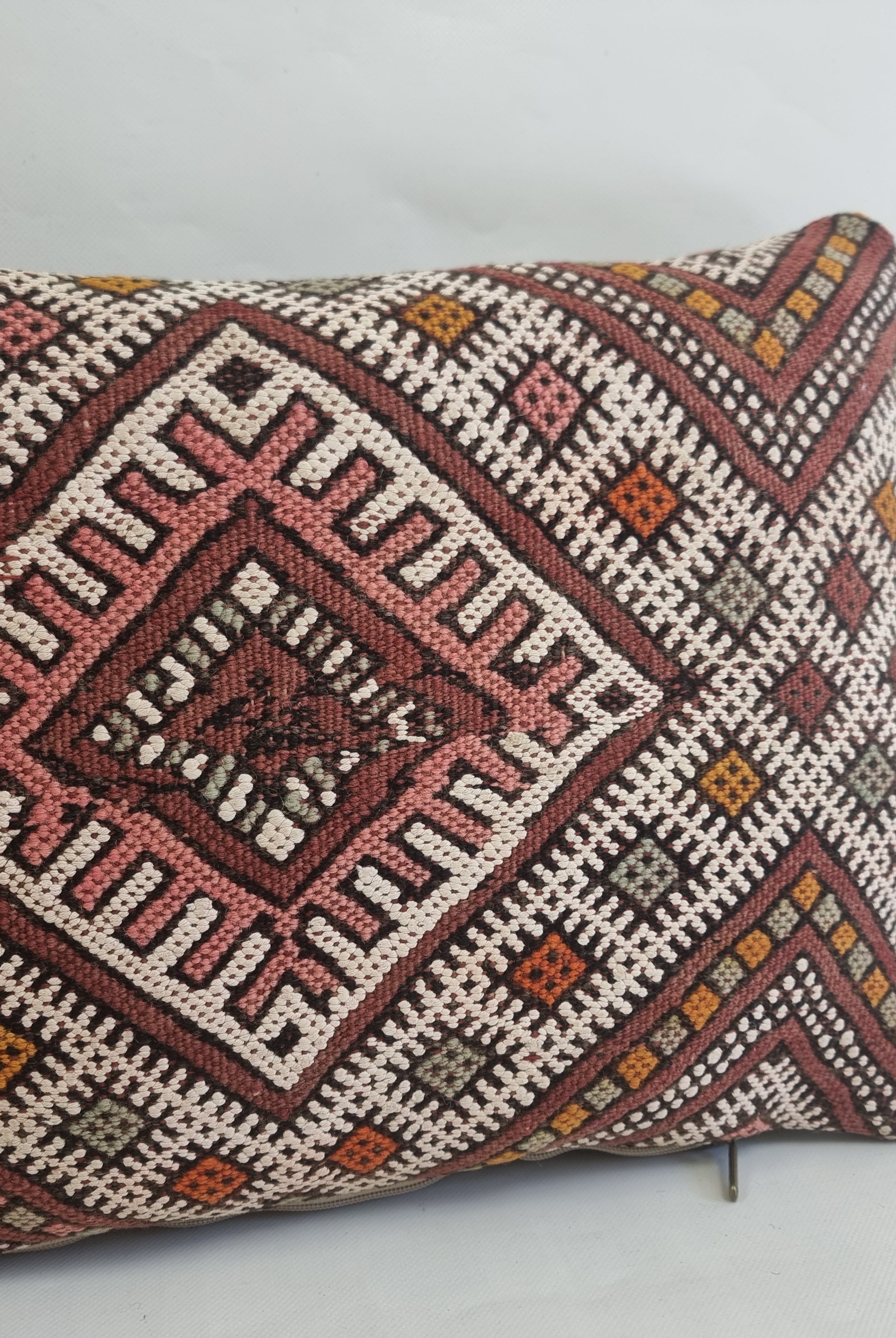 Decorative pillow with geometric pattern on a light gray background