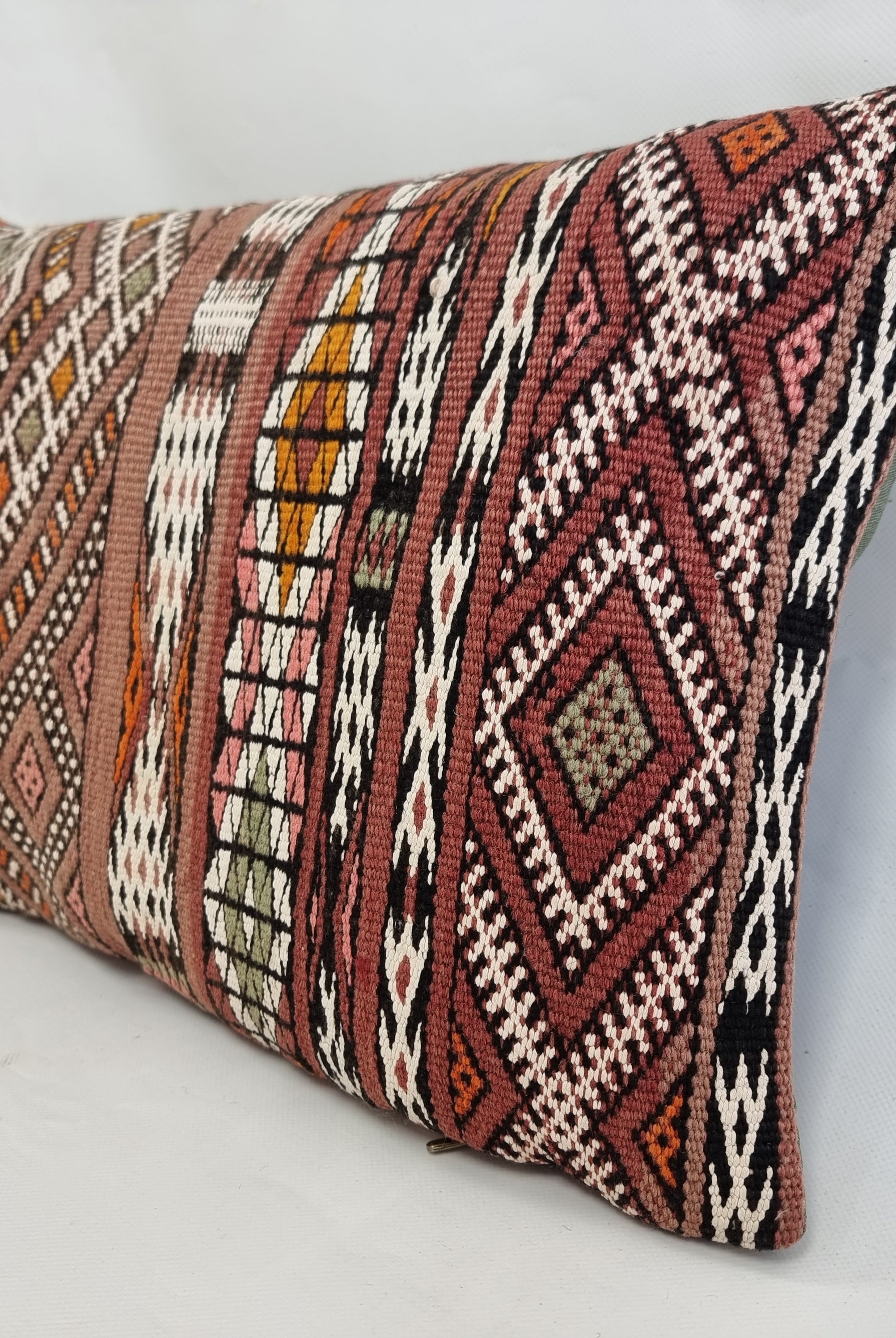 Decorative pillow with tribal pattern on a light gray background