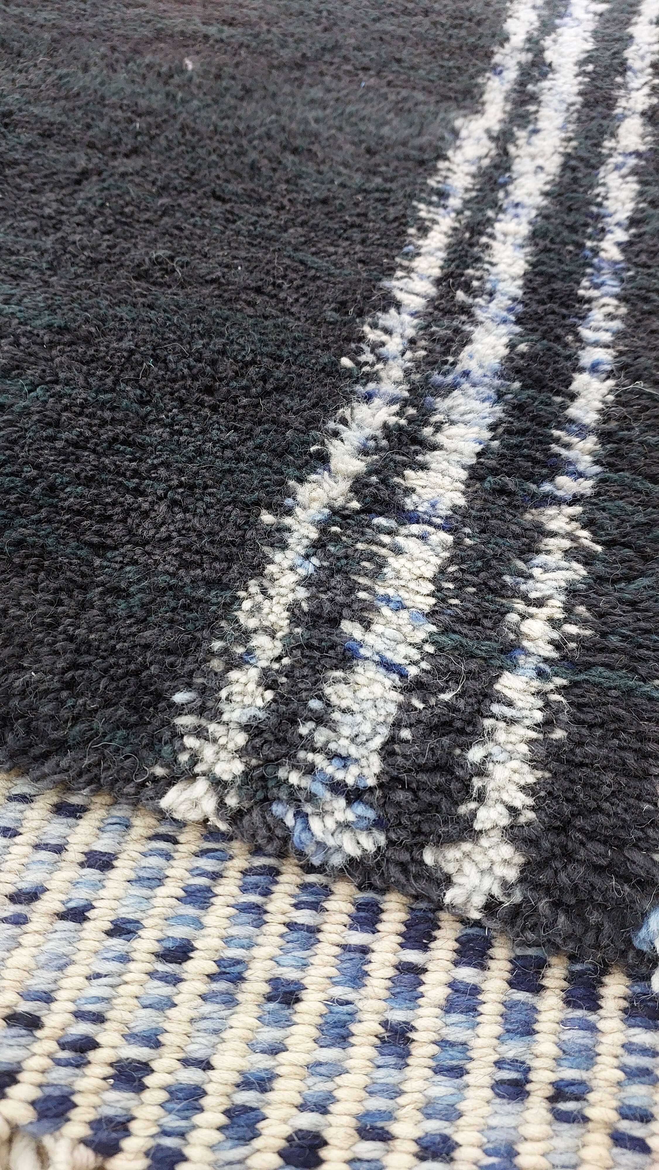 Detailed image of a blue and black striped Moroccan rug
