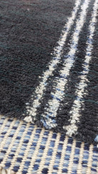 Detailed image of a blue and black striped Moroccan rug