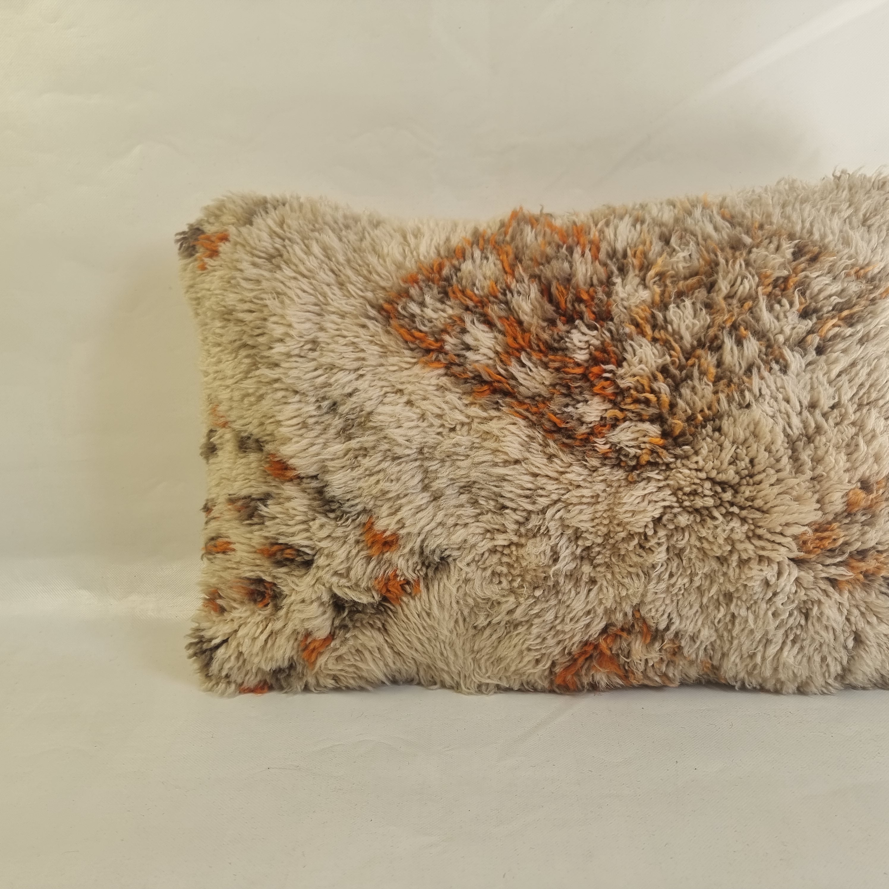 Handcrafted Moroccan-style shag lumbar pillow cover featuring a textured cream base with rust orange and brown geometric diamond motifs, isolated on a white background