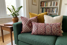 Green sofa with patterned cushions in a living room setting