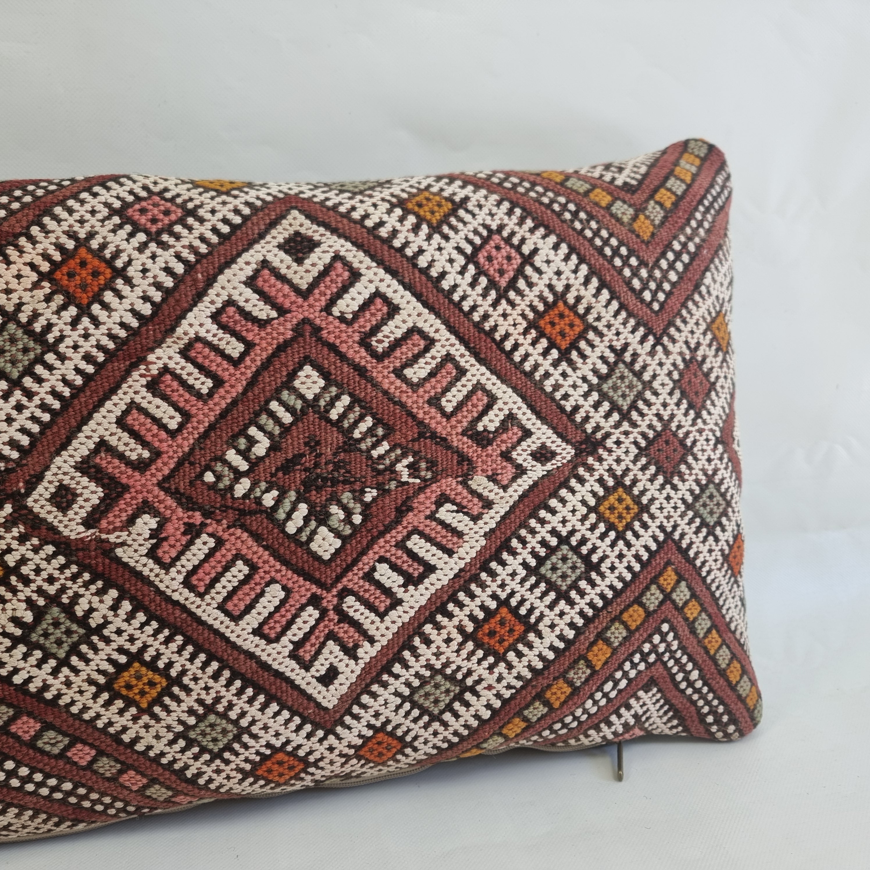 Decorative pillow with geometric pattern on a light gray background