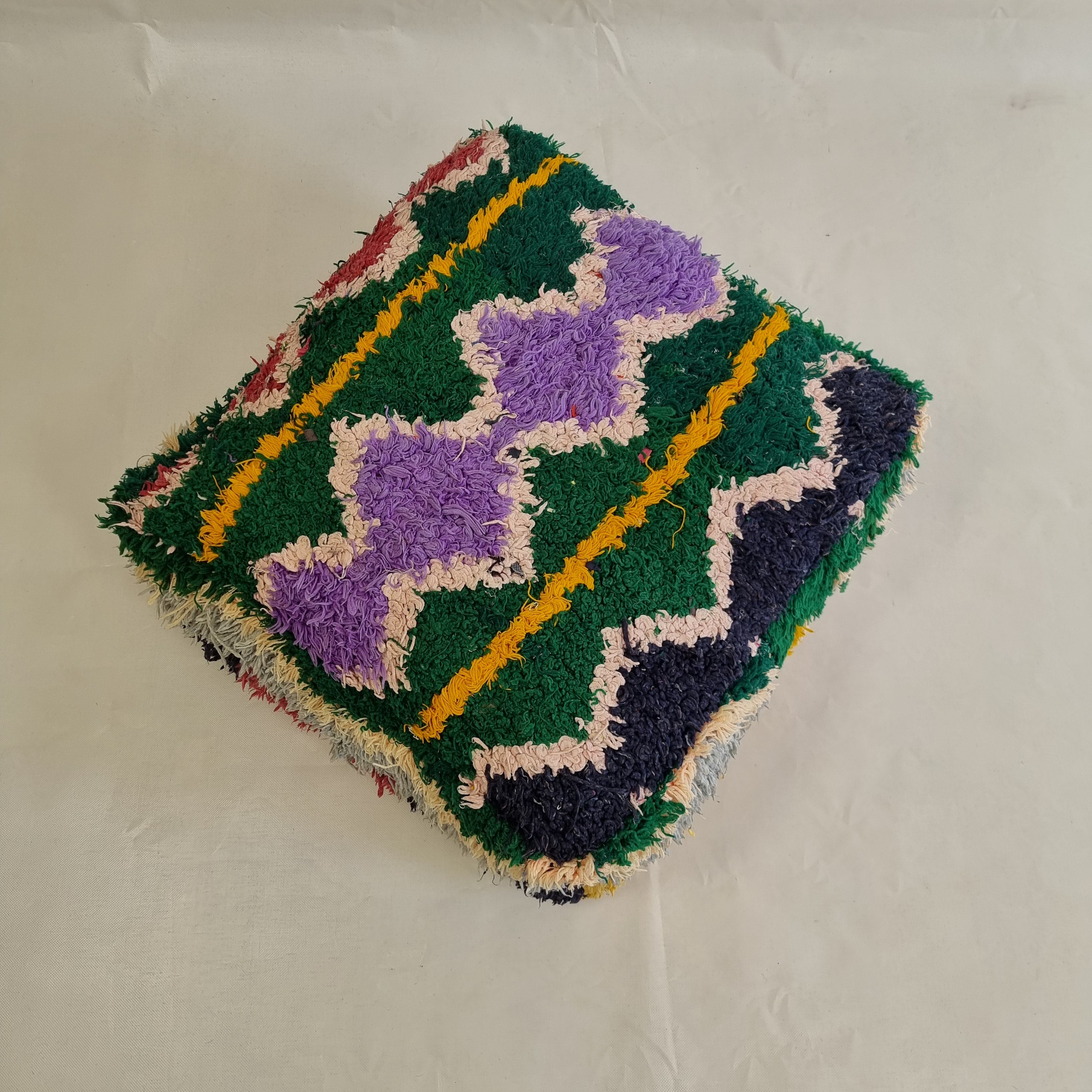 Multicolored textured fabric square on a plain background