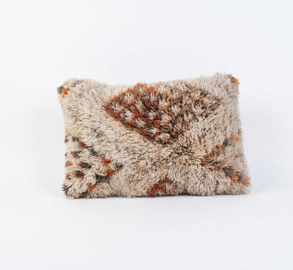Handcrafted Moroccan-style shag lumbar pillow cover featuring a textured cream base with rust orange and brown geometric diamond motifs, isolated on a white background.